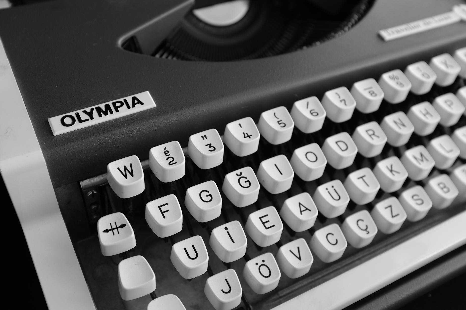 Close-up shot of an Olympia typewriter showing its German keyboard layout in black and white.