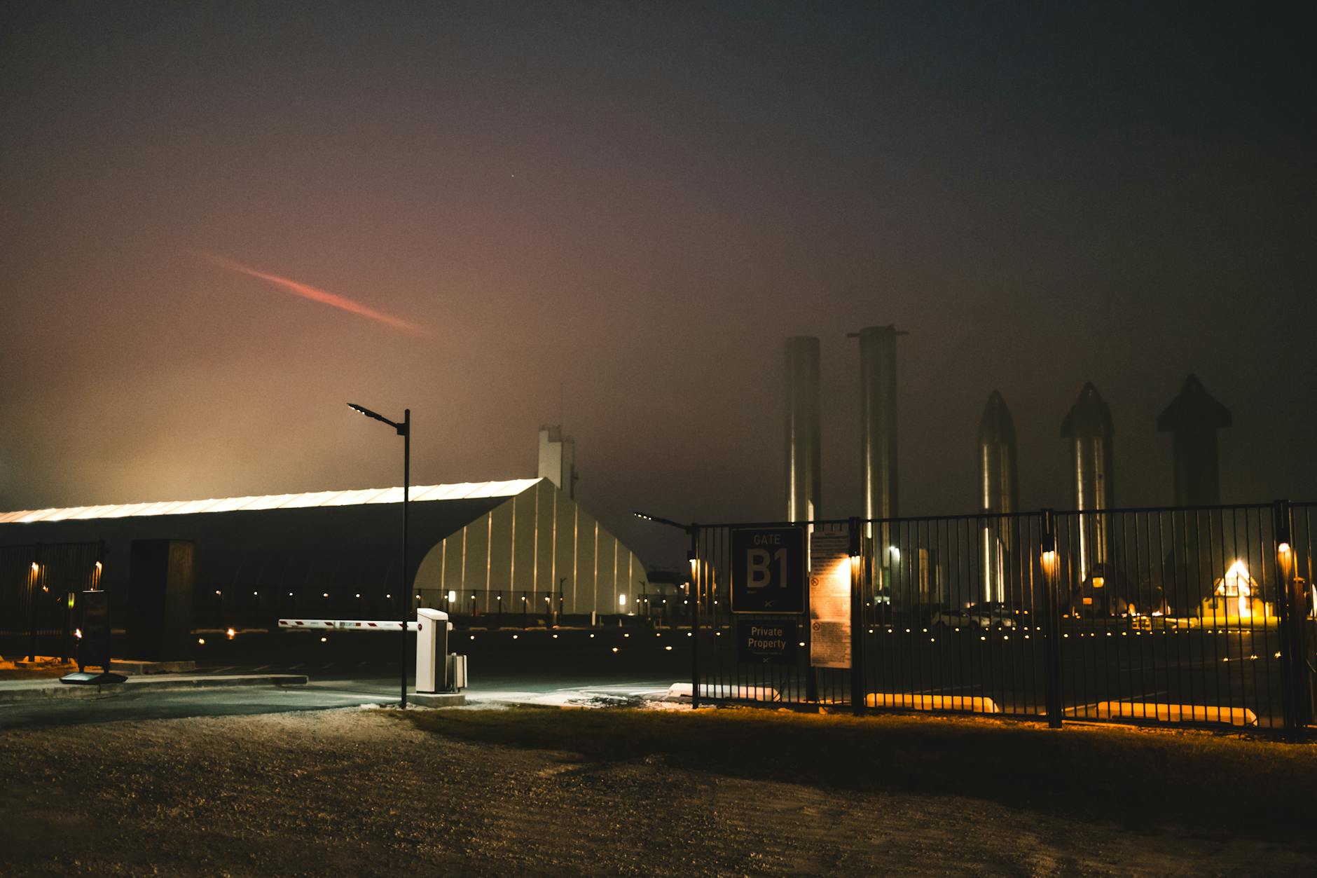 Dramatic night view of SpaceX facility with fog and lights in Brownsville, Texas.