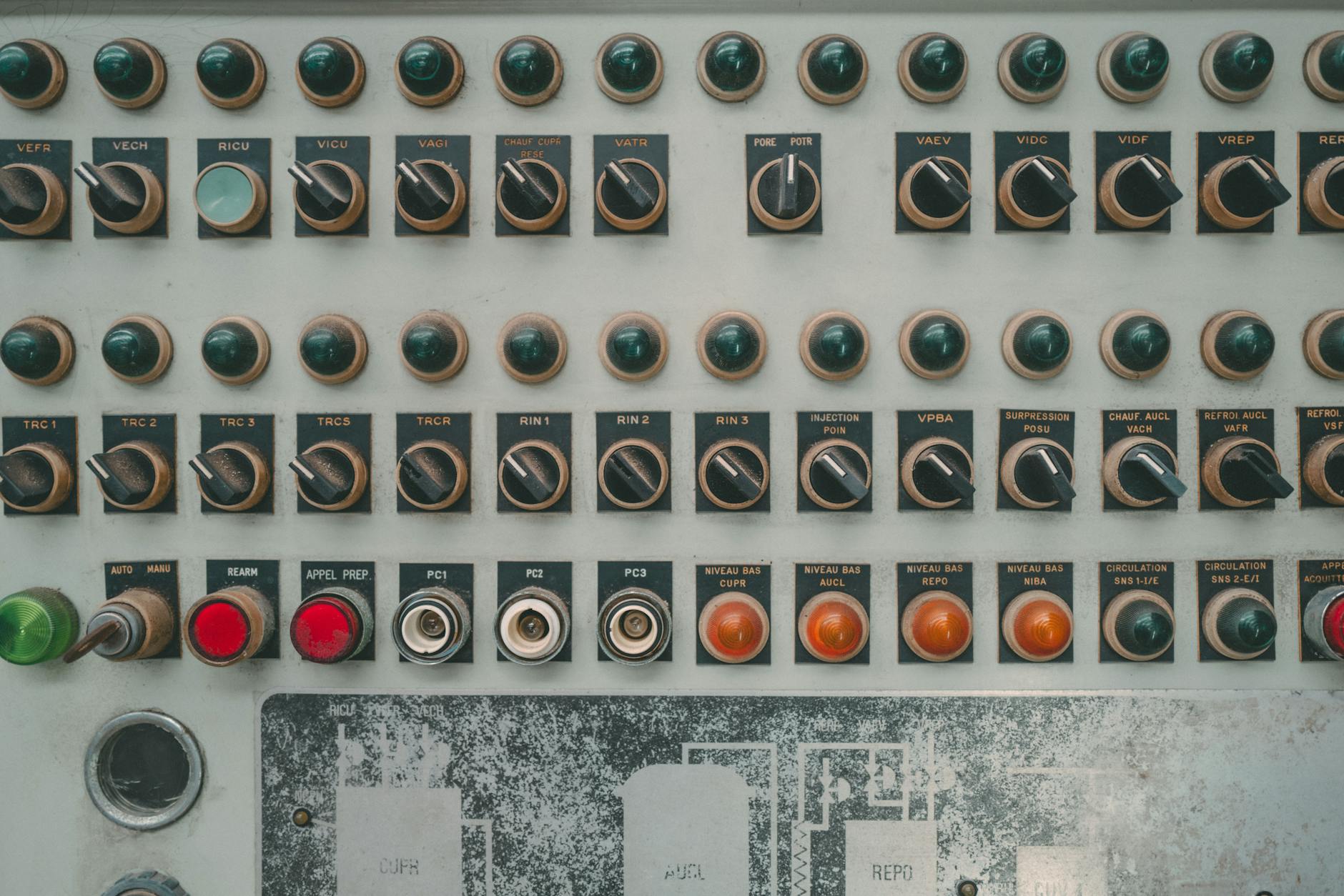 Close-up of a vintage industrial control panel with multiple buttons and switches.